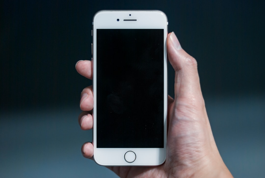 Hand holding mobile phone with app interface